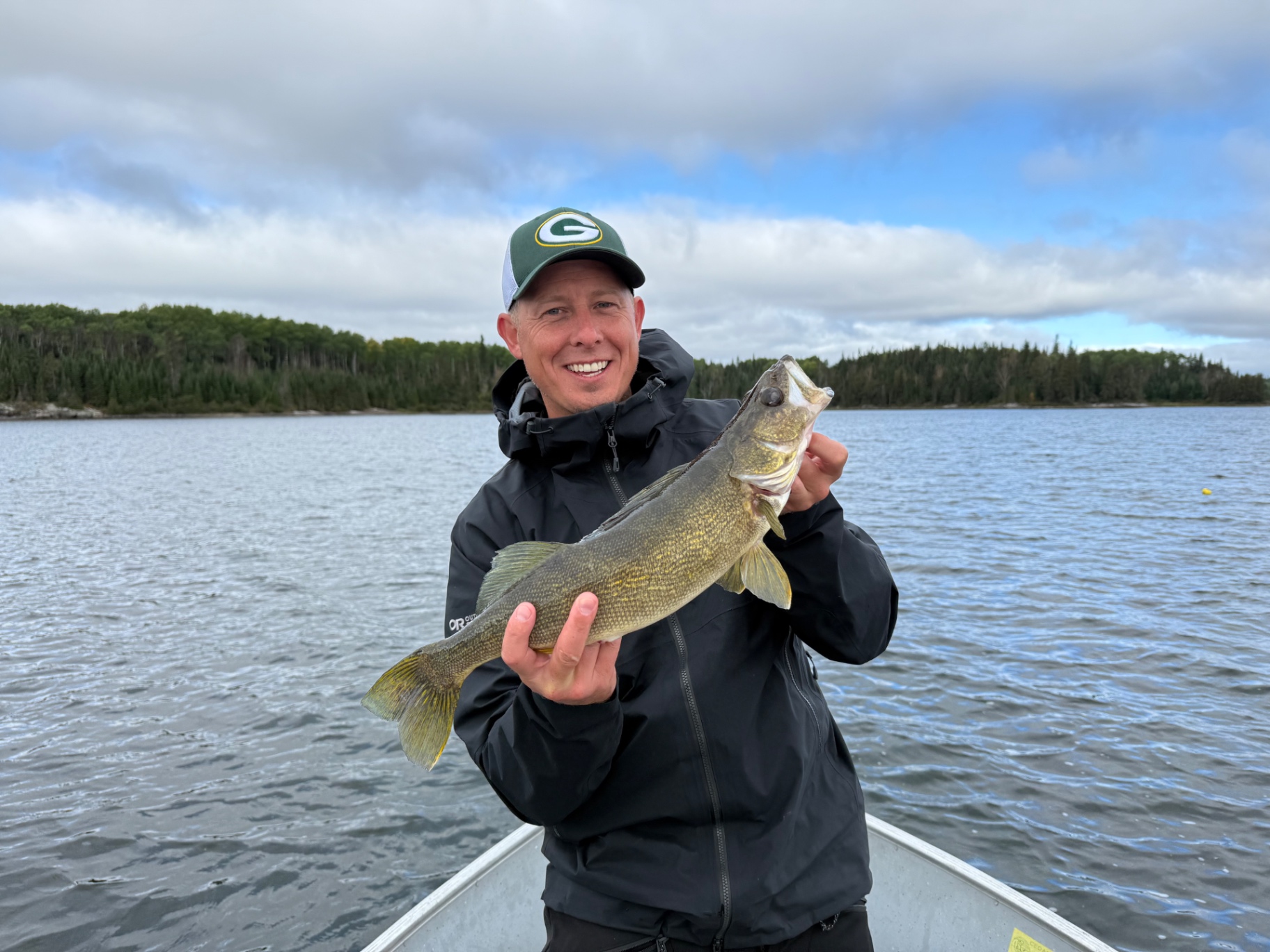 Angler in a Packers cap with a walleye